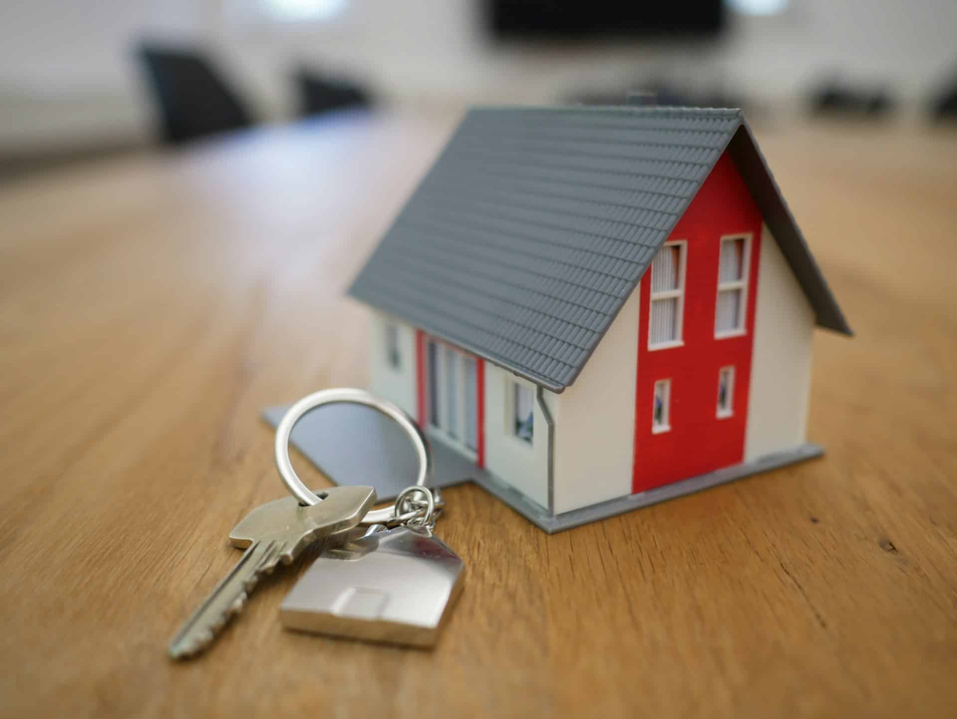 white wood house and a set of keys
