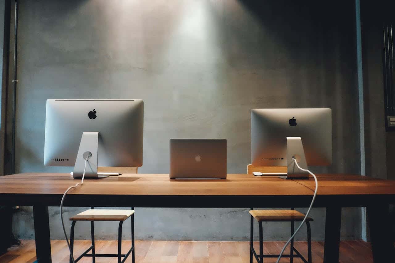 two iMac computers sitting on a desk