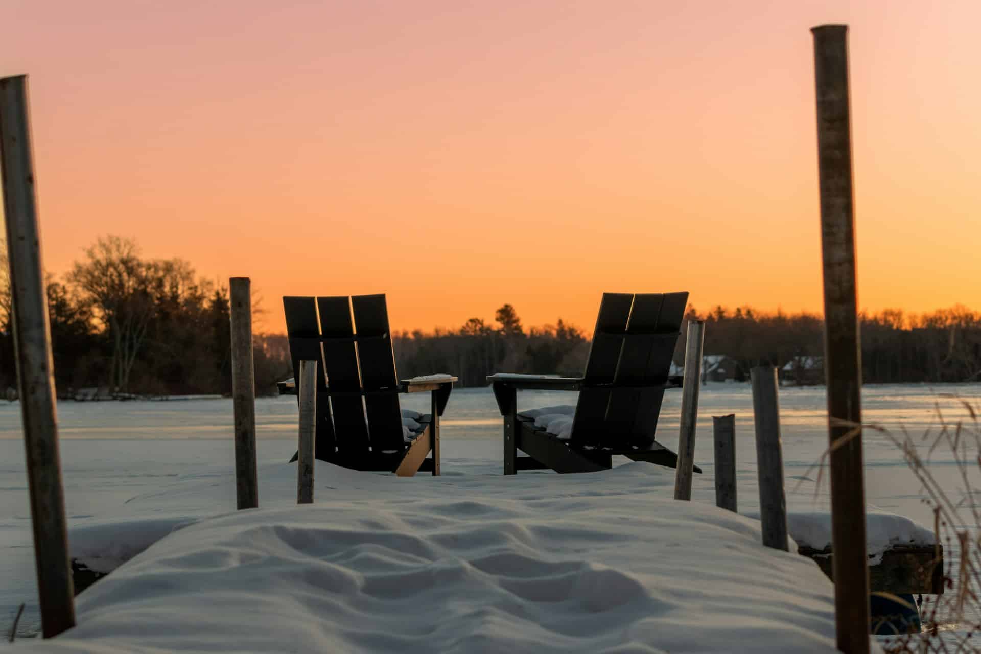 two chairs on a dock in wintertime